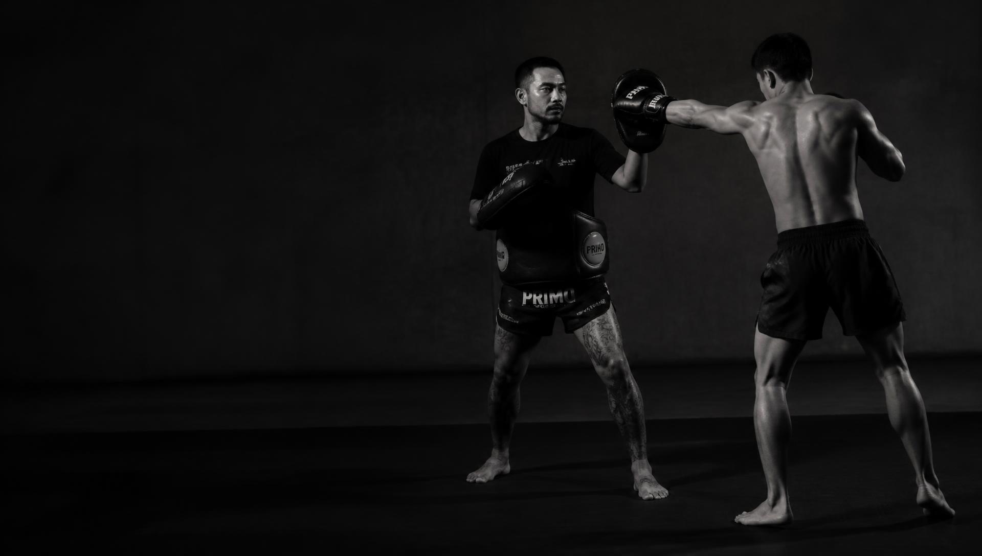 Erick Sampaio treinando um aluno de Muay Thai com aparadores